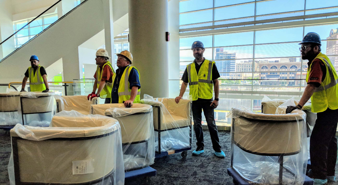 Workers moving chairs at the Fiserv Forum